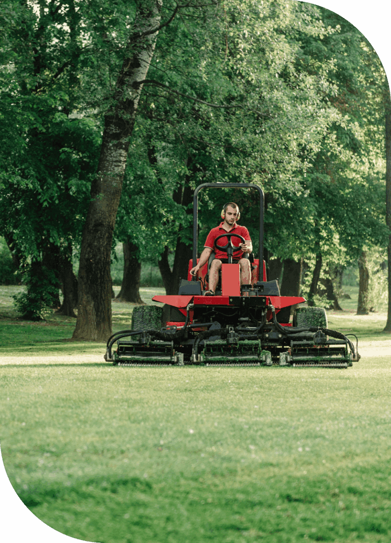 Person mowing grass on red lawn mower.